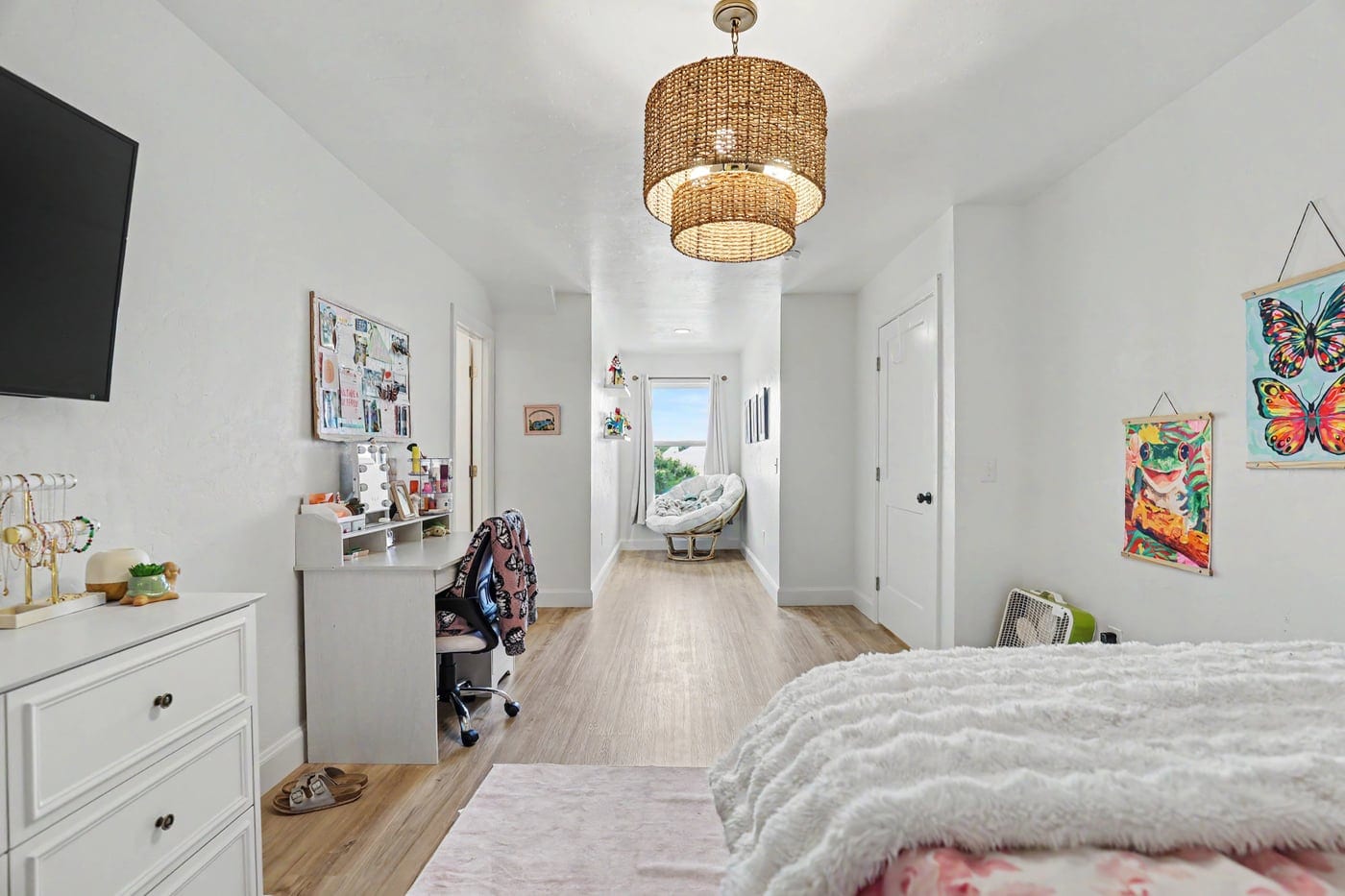 Converted attic bedroom with woven pendant light and hallway