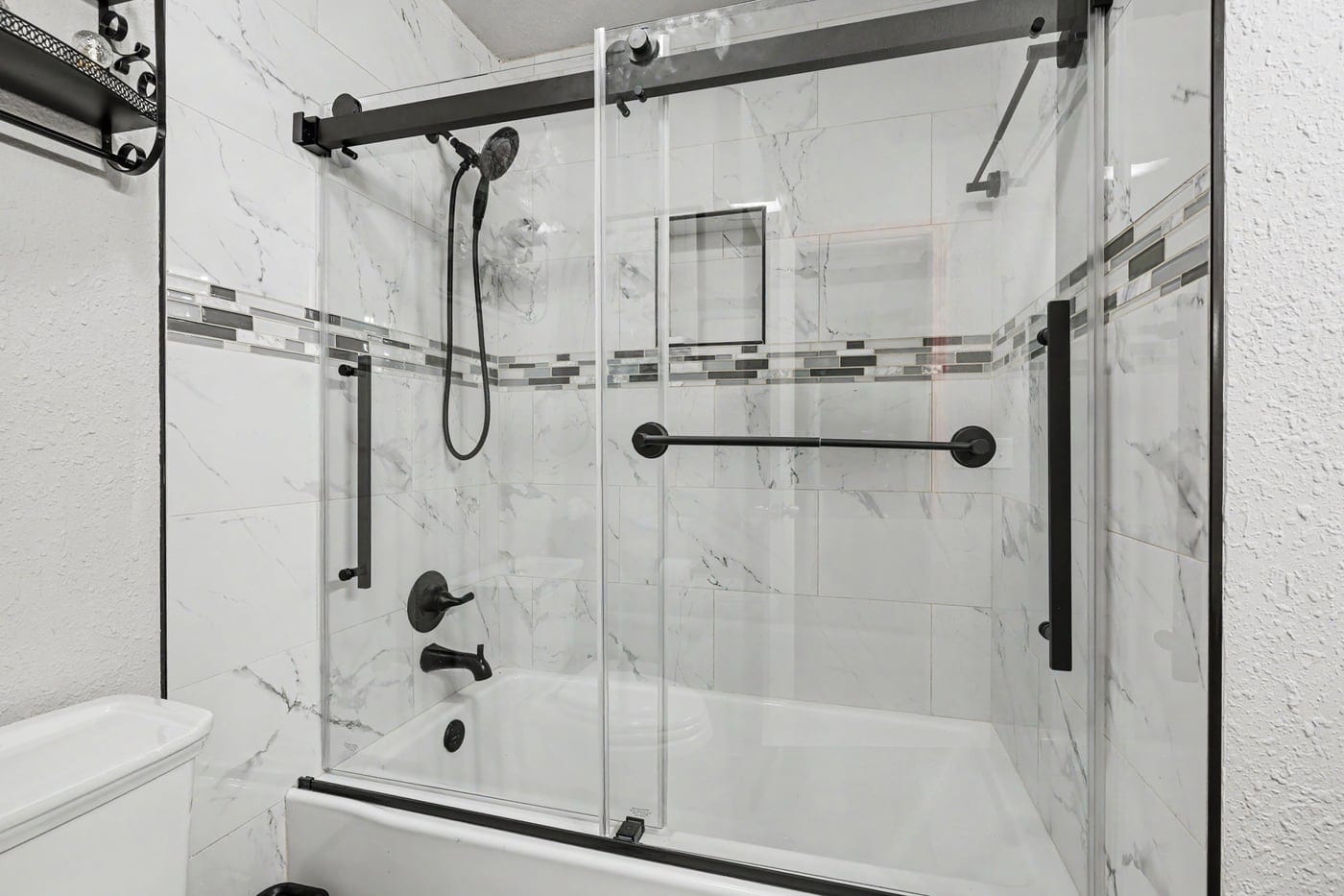Tub with sliding glass doors and matte black fixtures