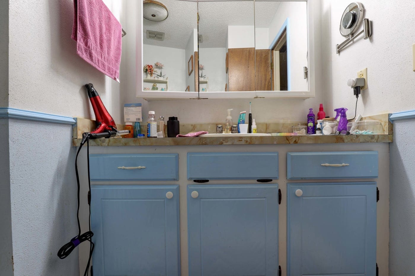 Blue vanity with laminate countertop before the remodel