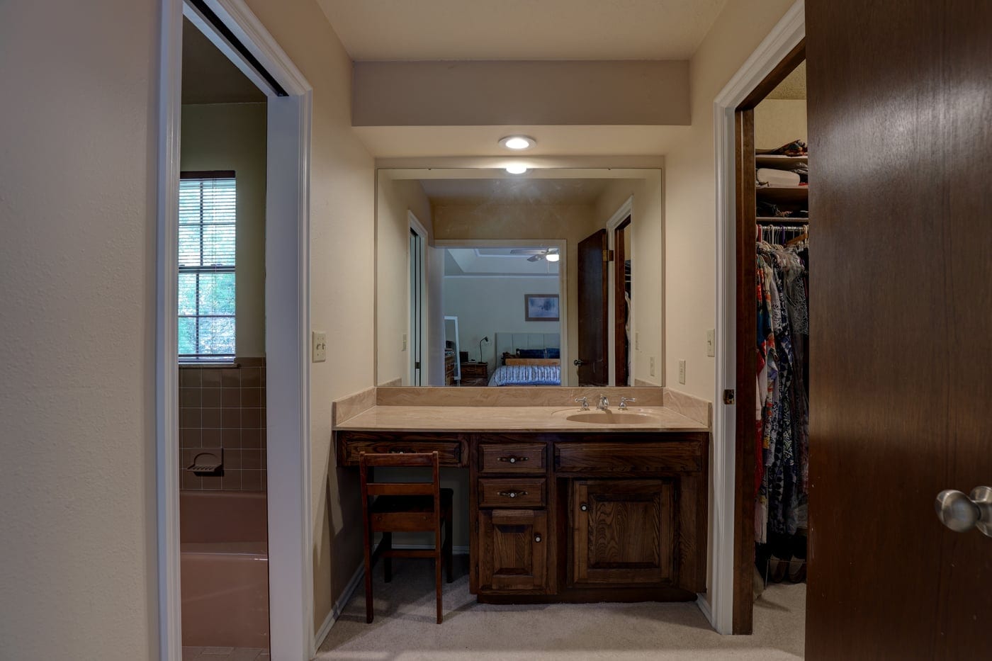 Dated makeup vanity with dark wood cabinets before the remodel