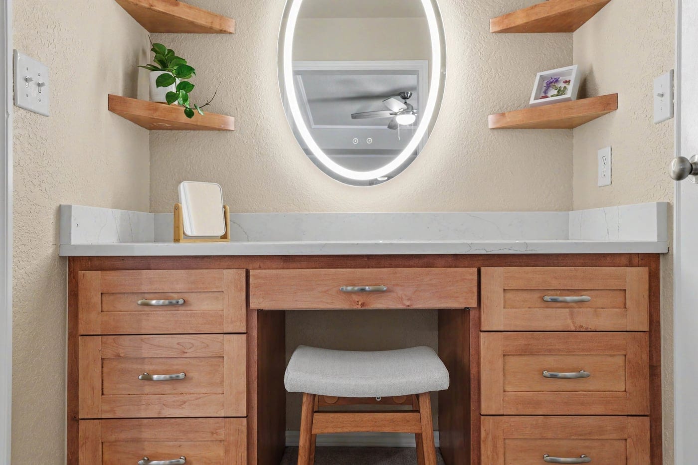 Built-in makeup vanity with backlit oval mirror