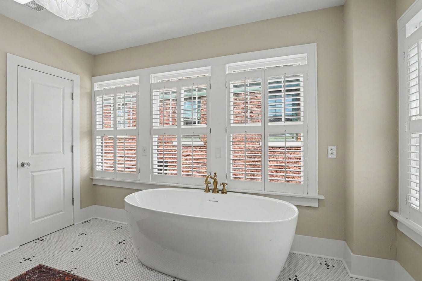 Freestanding soaking tub under plantation shutters